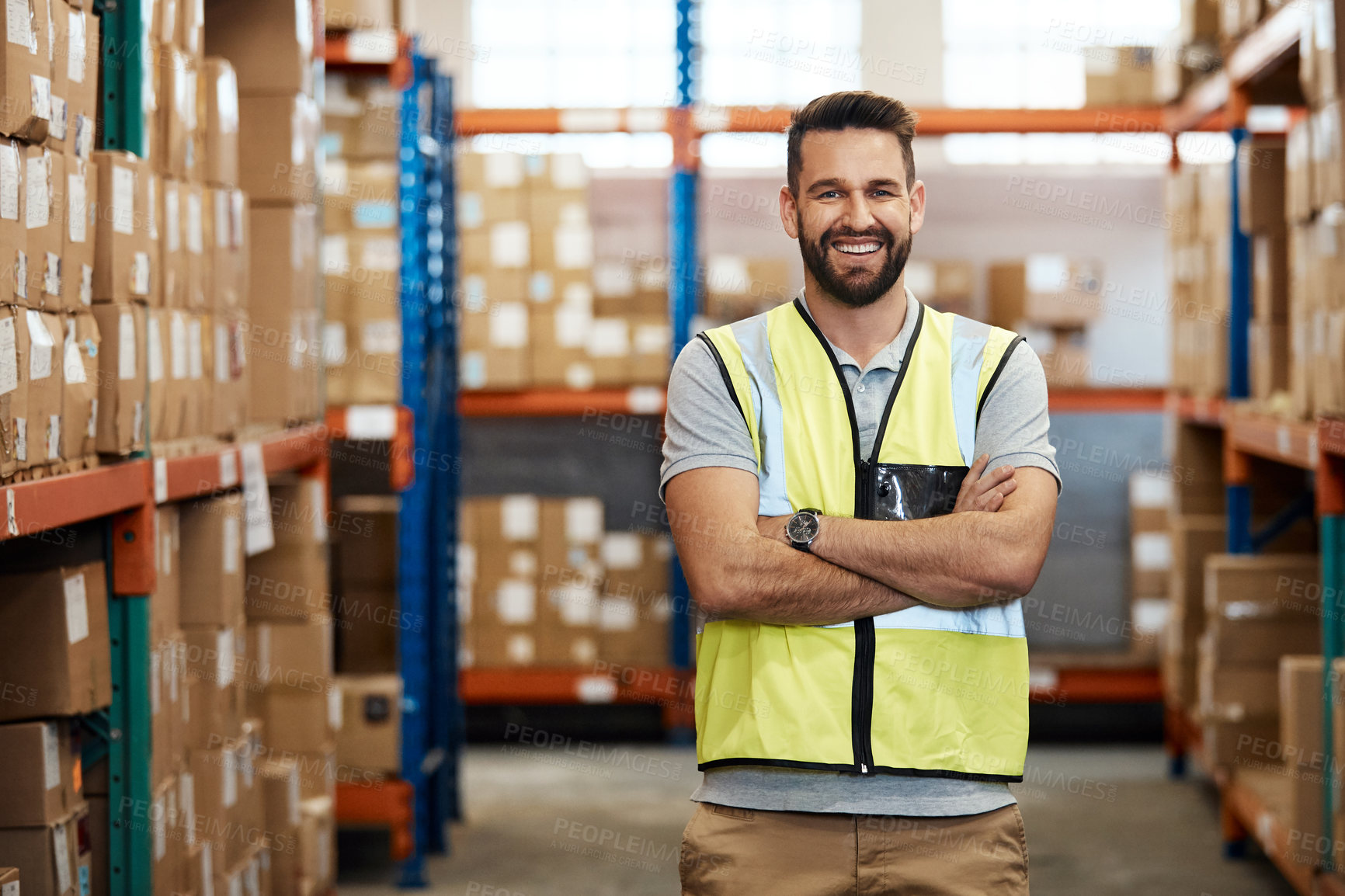Buy stock photo Cropped portrait of a handsome young male warehouse worker standing with his arms crossed