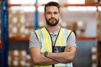 Buy stock photo Cropped portrait of a handsome young male warehouse worker standing with his arms crossed