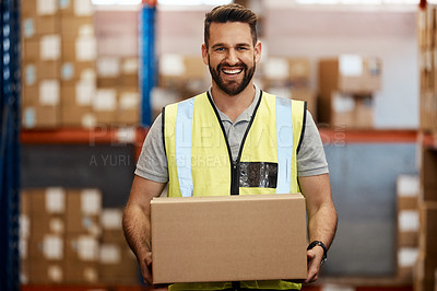 Buy stock photo Cropped portrait of a handsome young male warehouse worker carrying a box