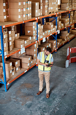 Buy stock photo High angle shot of a handsome young male warehouse worker checking stock