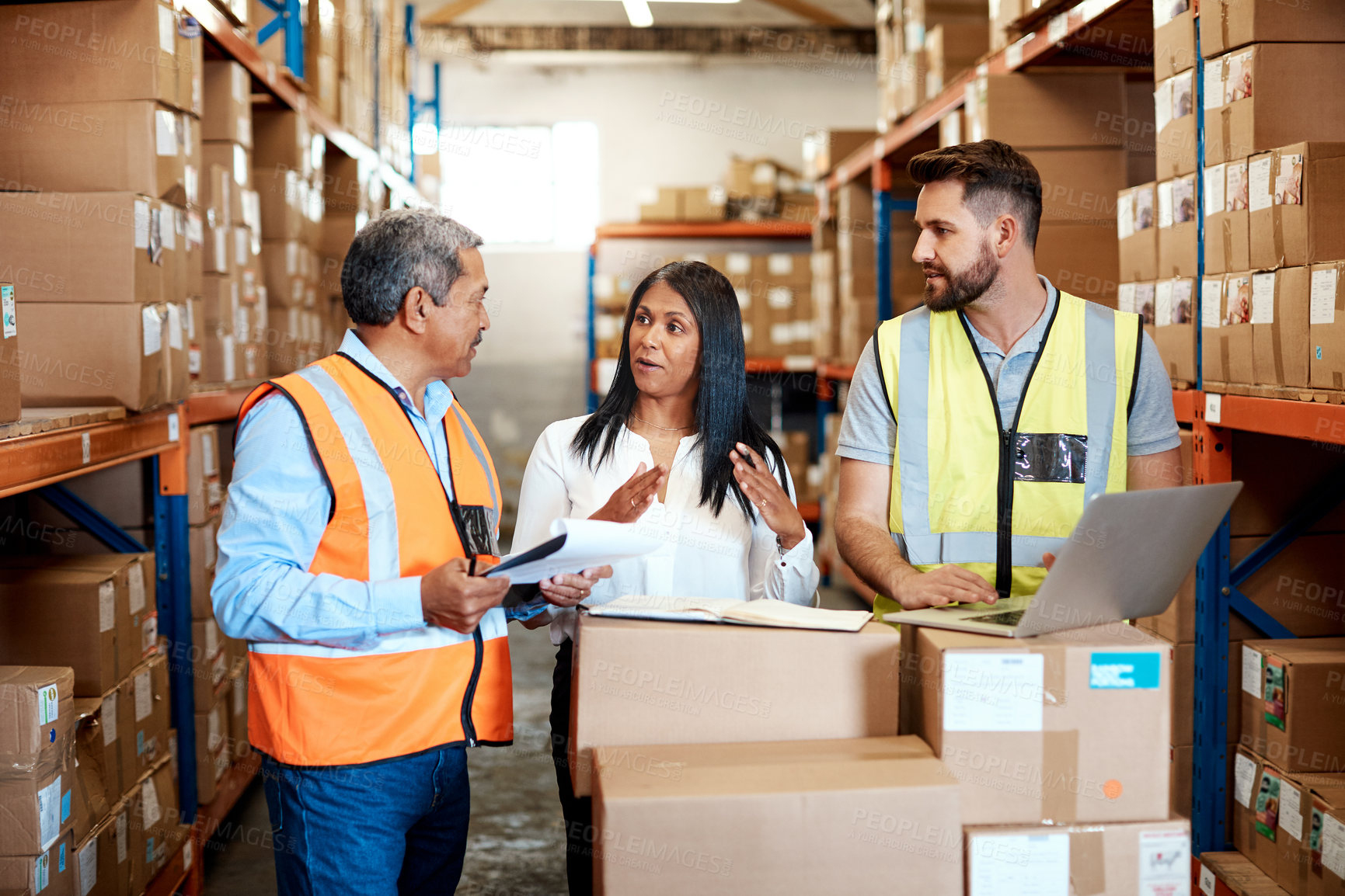 Buy stock photo Cropped shot of three warehouse workers checking on distribution logistics