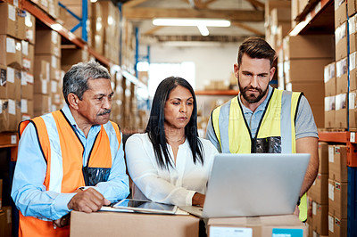 Buy stock photo Cropped shot of three warehouse workers checking on distribution logistics
