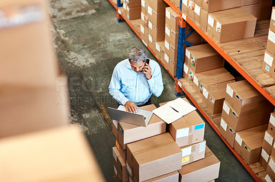 Buy stock photo High angle shot of a handsome mature male warehouse worker working on a laptop