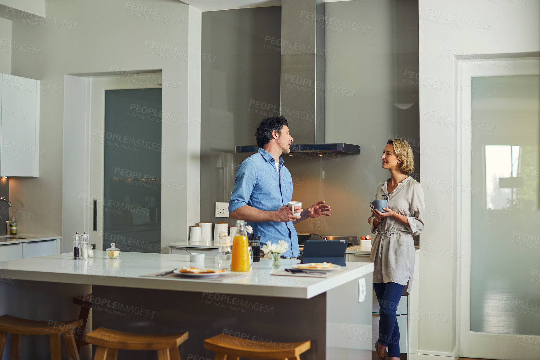 Buy stock photo Shot of a mature couple having coffee together in the kitchen at home