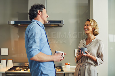 Buy stock photo Shot of a mature couple having coffee together in the kitchen at home
