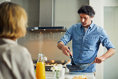 Buy stock photo Shot of a mature man preparing breakfast for him and his wife at home