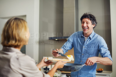Buy stock photo Shot of a mature man preparing breakfast for him and his wife at home