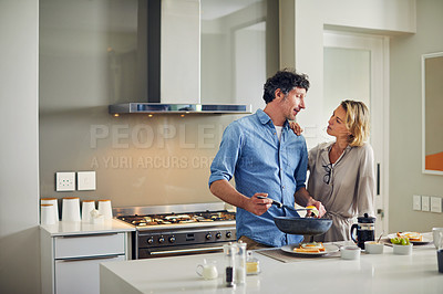 Buy stock photo Shot of a mature man preparing breakfast for him and his wife at home