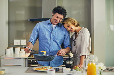 Buy stock photo Shot of a mature man preparing breakfast for him and his wife at home