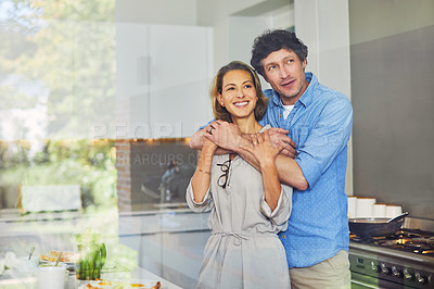 Buy stock photo Shot of a mature couple hugging in the kitchen at home
