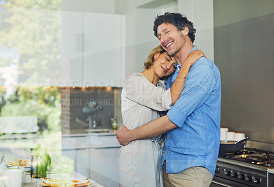 Buy stock photo Shot of a mature couple hugging in the kitchen at home