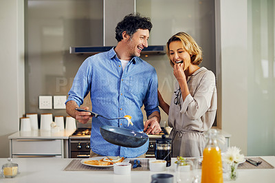 Buy stock photo Shot of a mature man preparing breakfast for him and his wife at home