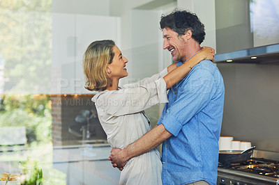 Buy stock photo Shot of a mature couple hugging in the kitchen at home