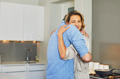 Buy stock photo Shot of a mature couple hugging in the kitchen at home