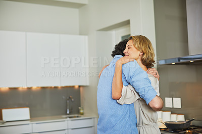 Buy stock photo Shot of a mature couple hugging in the kitchen at home