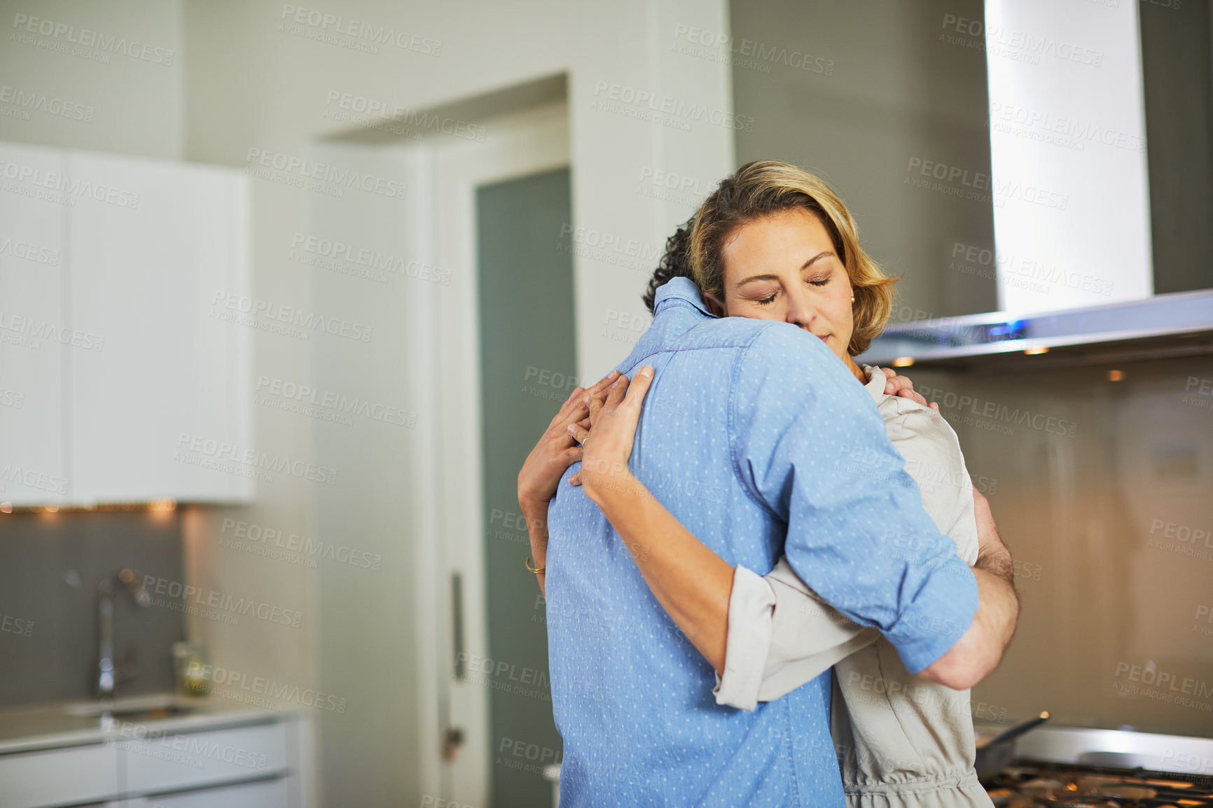 Buy stock photo Shot of a mature couple hugging in the kitchen at home
