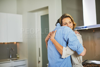 Buy stock photo Shot of a mature couple hugging in the kitchen at home