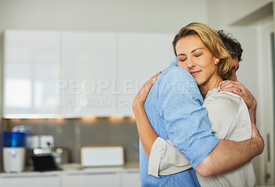 Buy stock photo Shot of a mature couple hugging in the kitchen at home