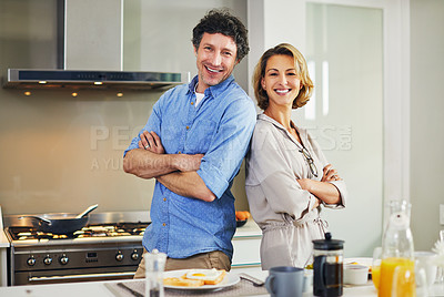 Buy stock photo Portrait of a confident mature couple preparing breakfast together at home