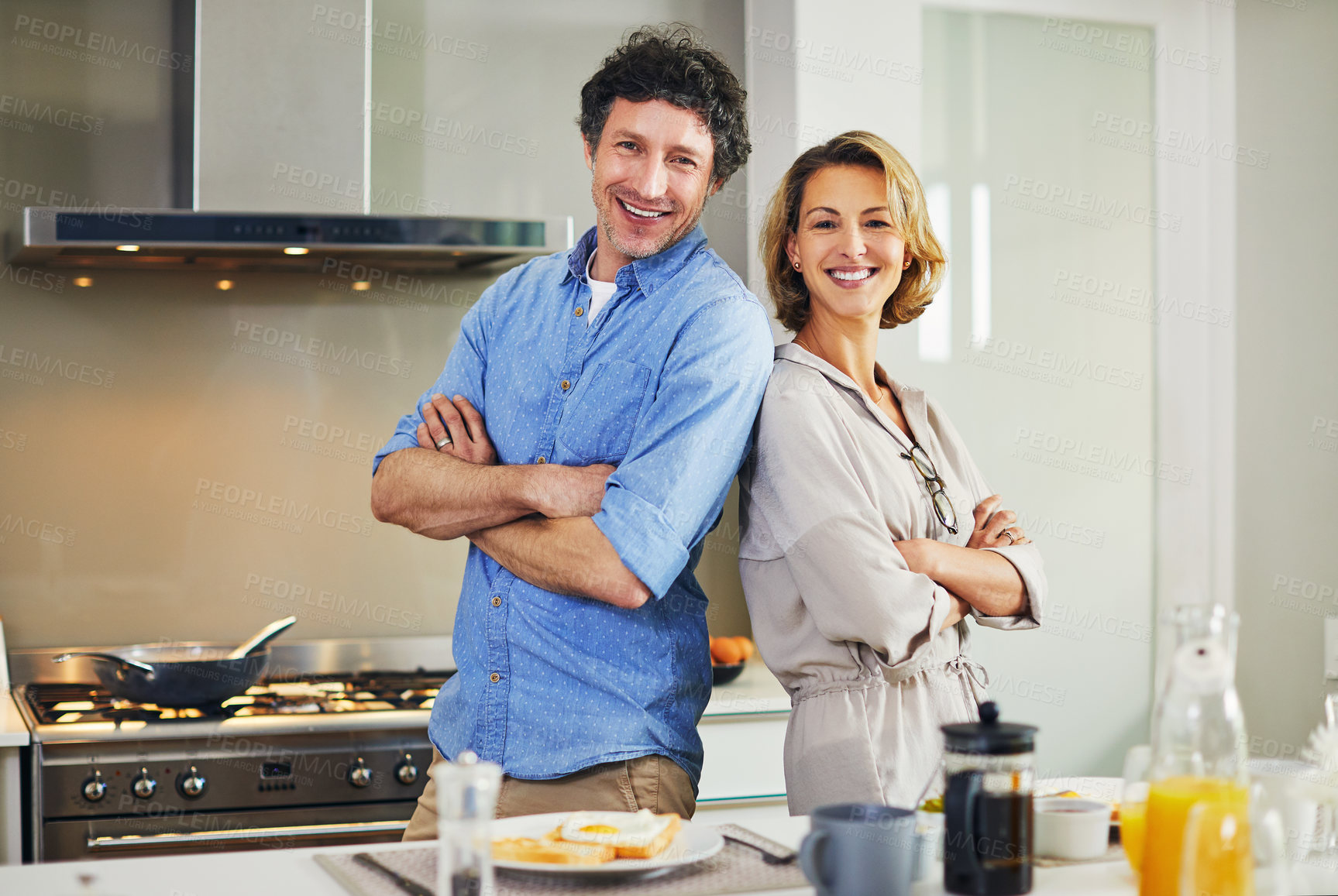 Buy stock photo Portrait of a confident mature couple preparing breakfast together at home