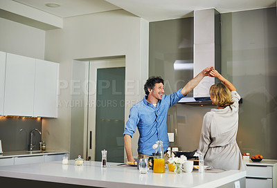 Buy stock photo Shot of a mature couple dancing while preparing breakfast in the kitchen at home