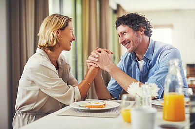 Buy stock photo Shot of a mature couple sharing romantic moment while having breakfast at home