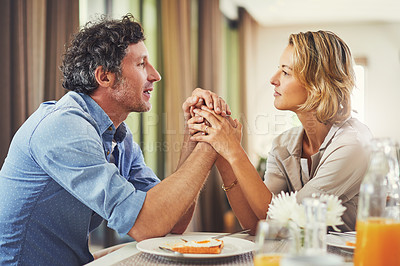 Buy stock photo Shot of a mature couple sharing romantic moment while having breakfast at home