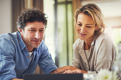 Buy stock photo Shot of a mature couple using a digital tablet at home
