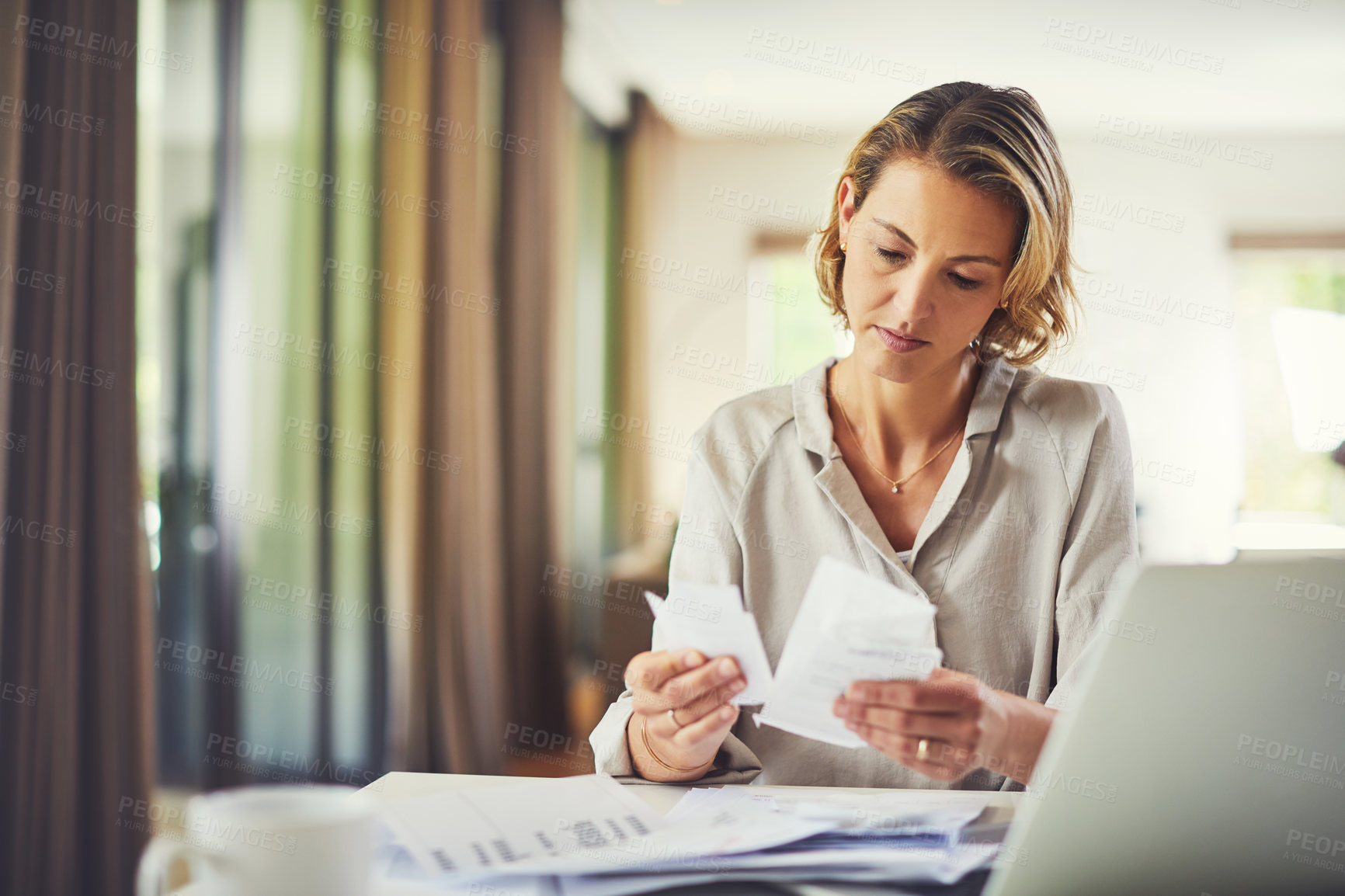 Buy stock photo Shot of a mature woman going over her finances at home