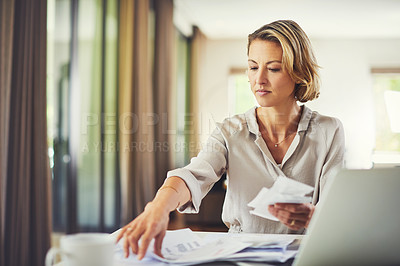 Buy stock photo Shot of a mature woman going over her finances at home