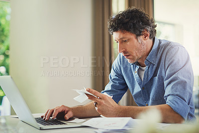 Buy stock photo Shot of a mature man going over his finances at home