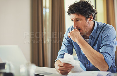 Buy stock photo Shot of a mature man going over his finances at home