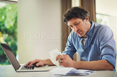 Buy stock photo Shot of a mature man going over his finances at home