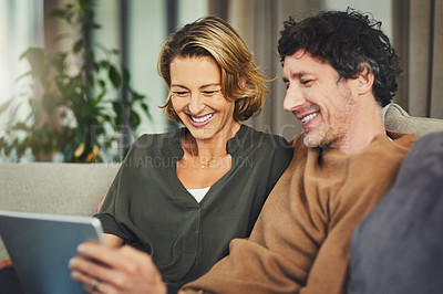 Buy stock photo Shot of a mature couple using a digital tablet on the sofa at home