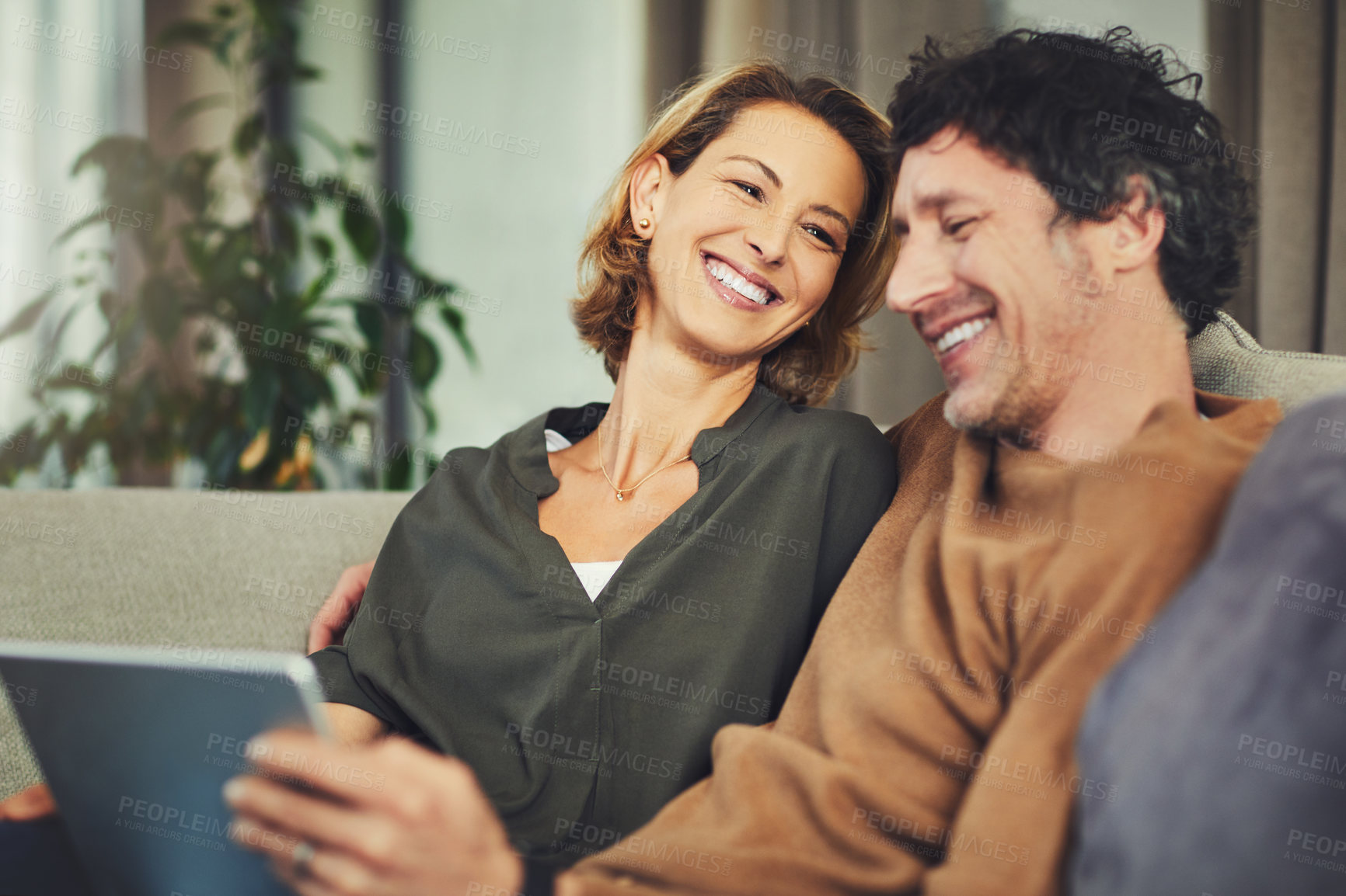 Buy stock photo Shot of a mature couple using a digital tablet on the sofa at home