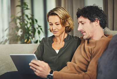 Buy stock photo Shot of a mature couple using a digital tablet on the sofa at home