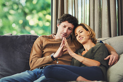 Buy stock photo Shot of an affectionate mature couple relaxing on the sofa at home