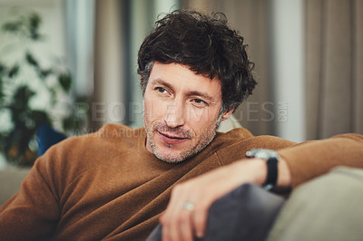 Buy stock photo Shot of a mature man looking thoughtful while relaxing on the sofa at home