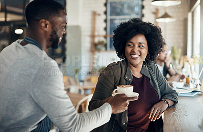Buy stock photo Cropped shot of a handsome young barista serving a coffee to a seated woman in the cafe
