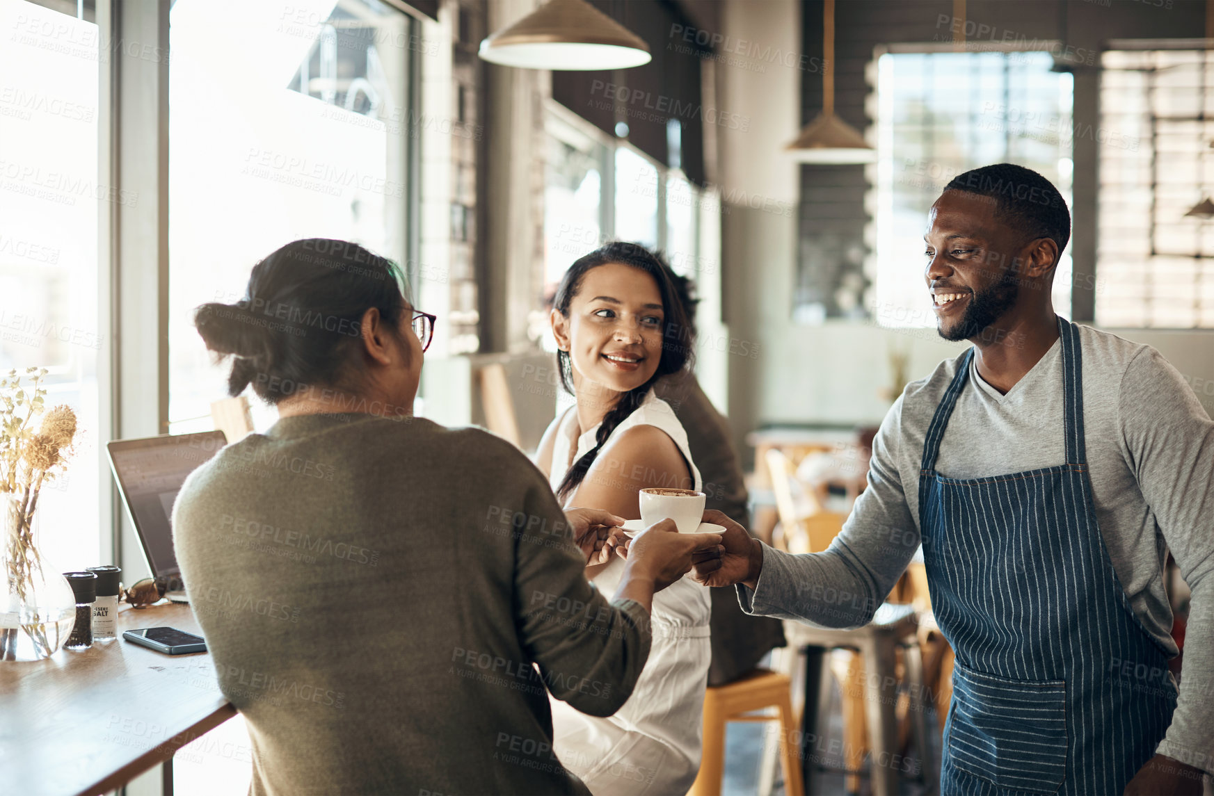 Buy stock photo Cropped shot of a handsome young businessman sitting with a female colleague and getting a coffee in a cafe