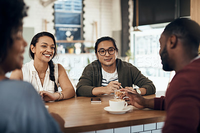 Buy stock photo Cropped shot of a young group of friends sitting together and bonding in a cafe during the day