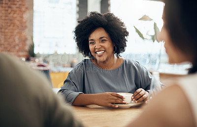 Buy stock photo Cropped shot of an attractive young woman sitting and enjoying a cup of coffee with her friends in a cafe