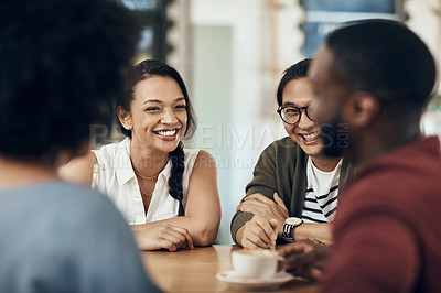 Buy stock photo Cropped shot of a young diverse group of friends sitting together and enjoying coffee in a cafe during the day