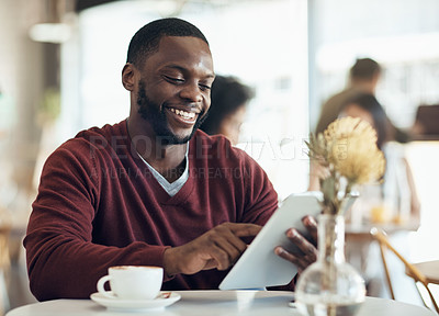 Buy stock photo Cropped shot of a handsome young businessman sitting in a cafe and using a tablet