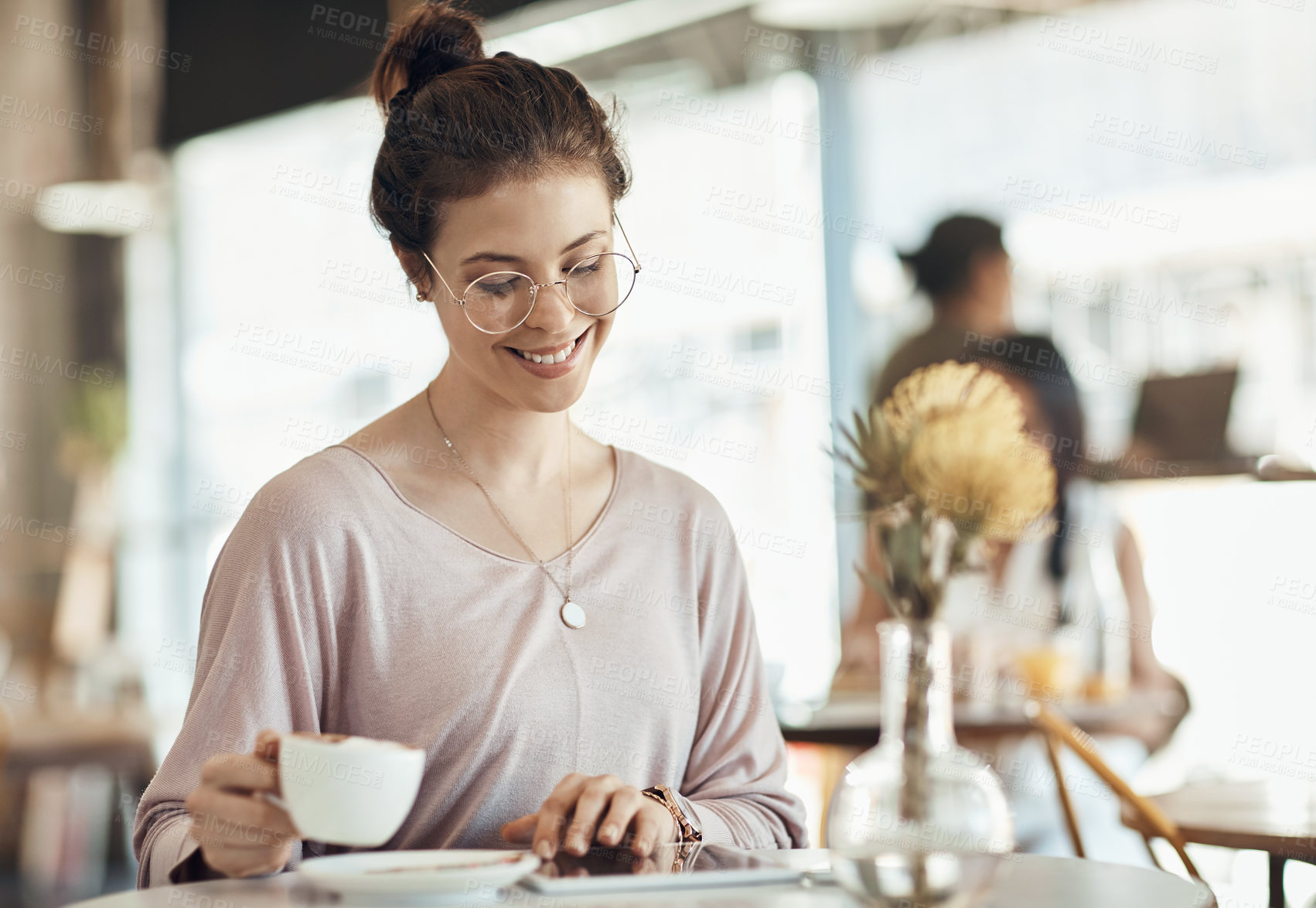 Buy stock photo Cropped shot of an attractive young businesswoman sitting in a cafe and using a tablet