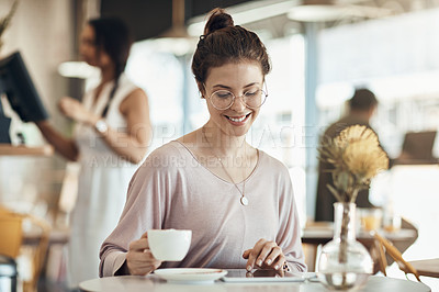 Buy stock photo Cropped shot of an attractive young businesswoman sitting in a cafe and using a tablet