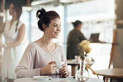 Buy stock photo Cropped shot of an attractive young woman sitting on her own and enjoying a cup of coffee in a cafe