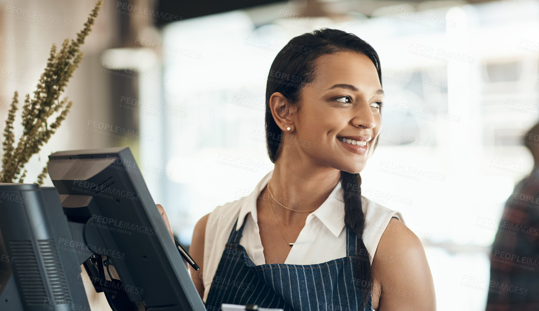 Buy stock photo Cropped shot of an attractive young waitress standing behind a till during her shift in a cafe