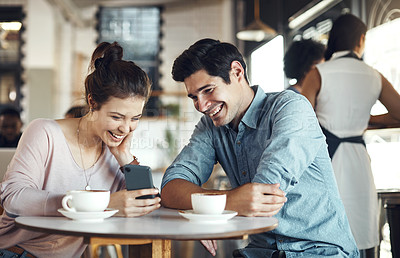 Buy stock photo Cropped shot of a happy couple sitting together and using a cellphone during a coffee date in a cafe