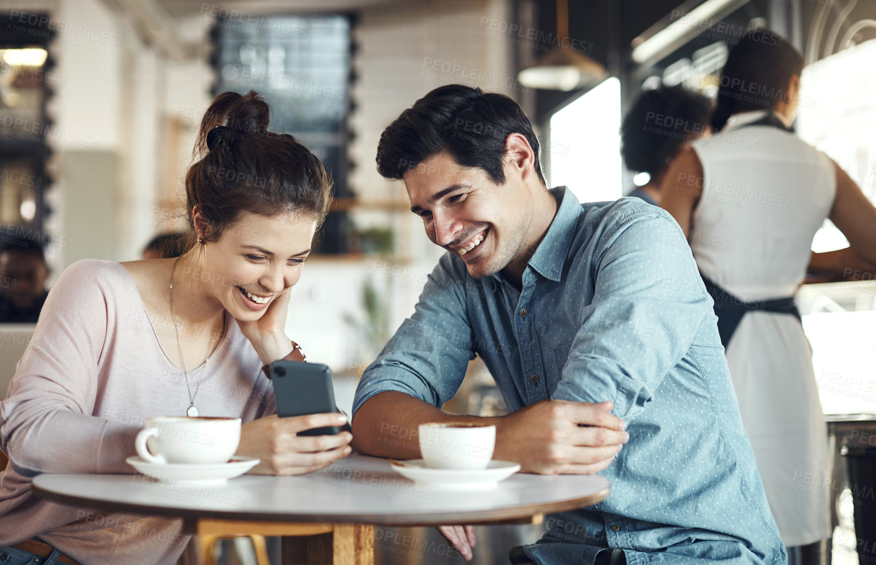 Buy stock photo Cropped shot of a happy couple sitting together and using a cellphone during a coffee date in a cafe